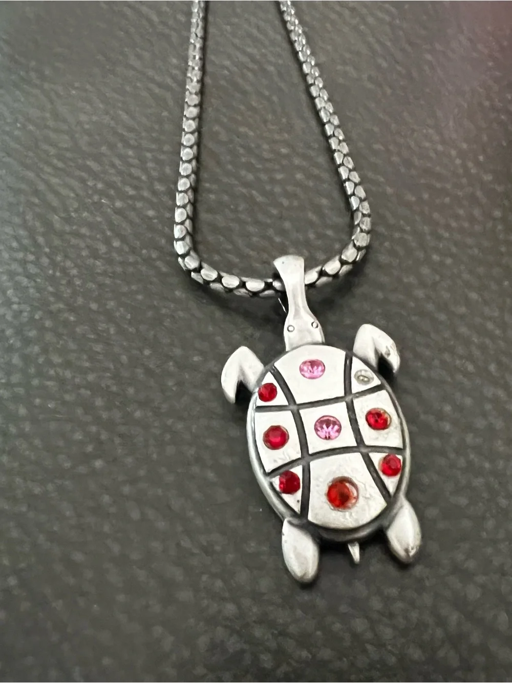 Silver tone Turtle Pendant Necklace with Red and Pink Accent Stones.